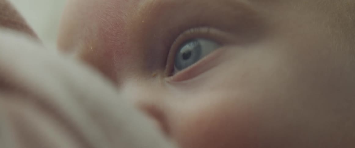Close up of a breast feeding baby with blue eyes