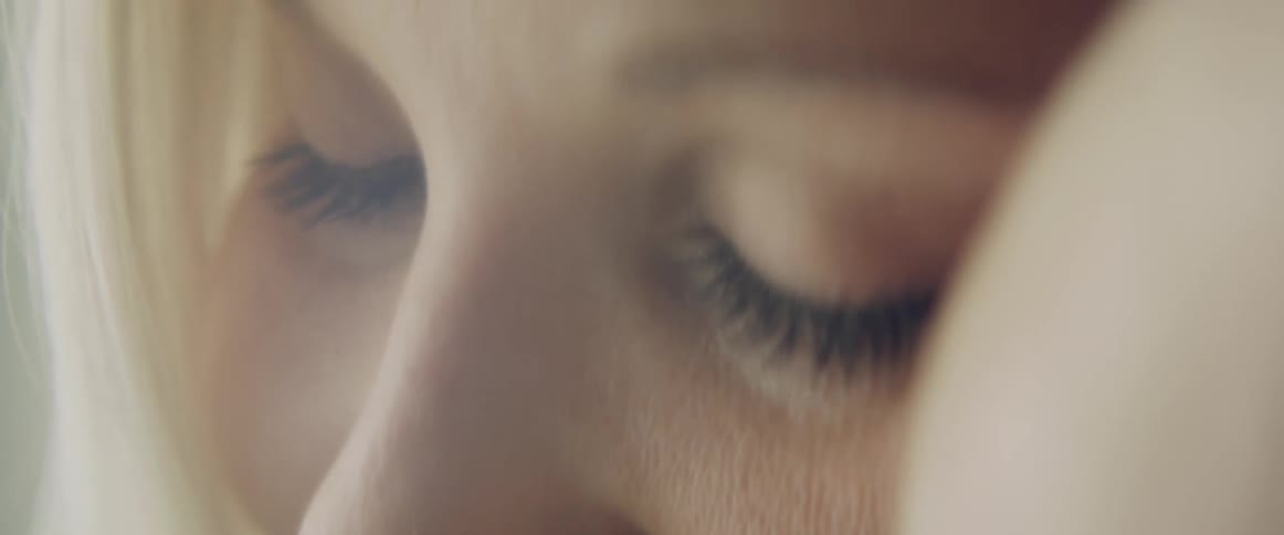 Close up of the face of a mother holding a baby near her face