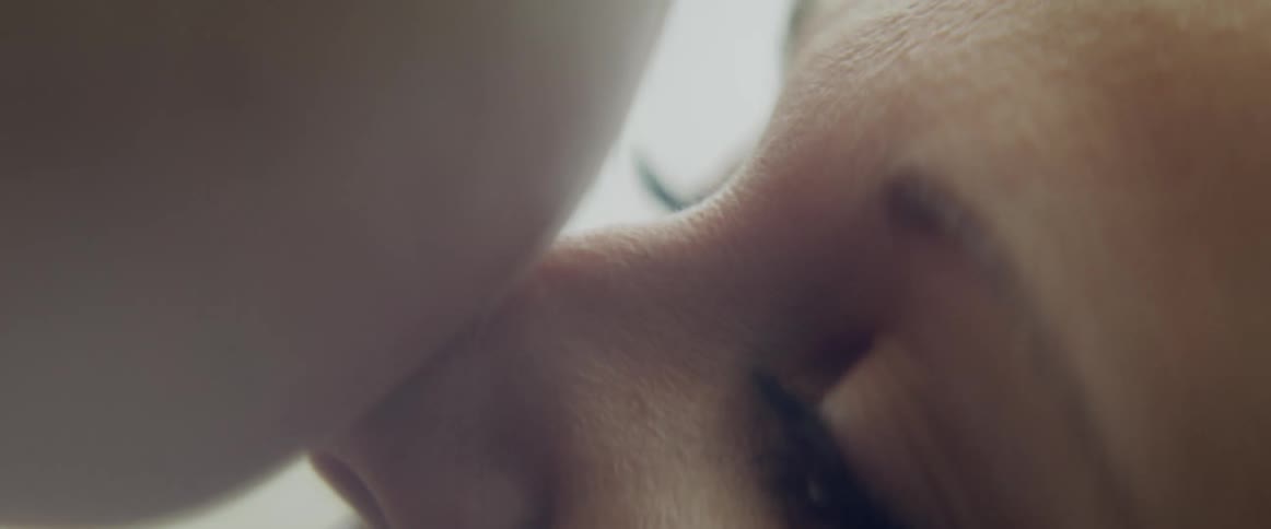 A woman lowers her son to her nose