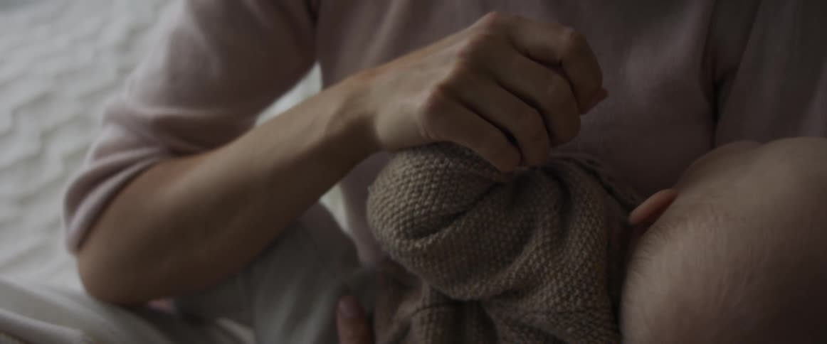 Mother lovingly holds baby in her hands at home