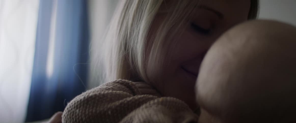 A woman hugs her baby boy as she holds him