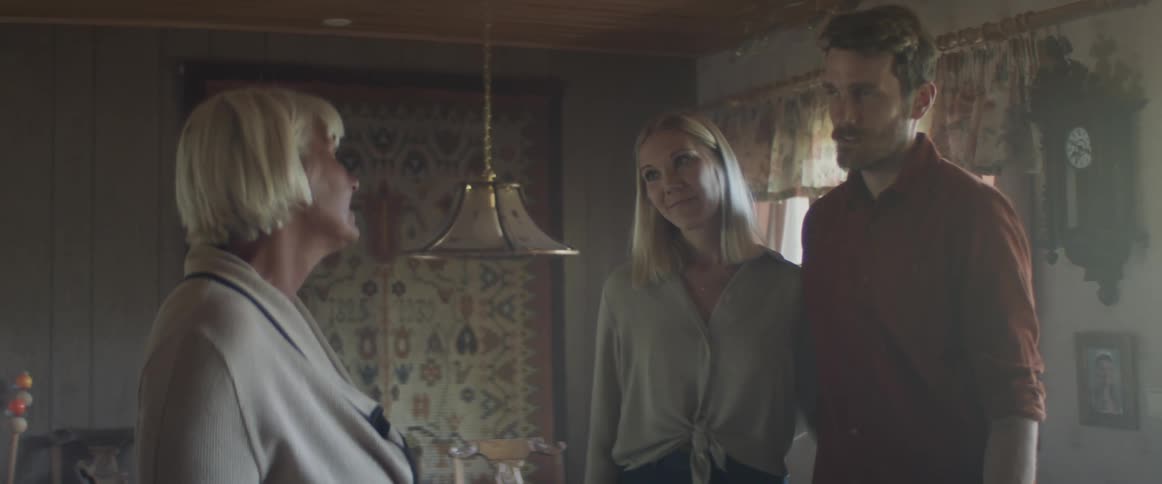 Couple smile as they talk to womans mother