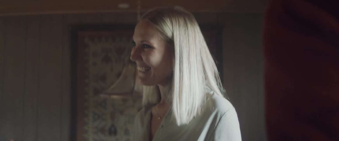 An elderly woman opens her door for her daughter and a man to come in
