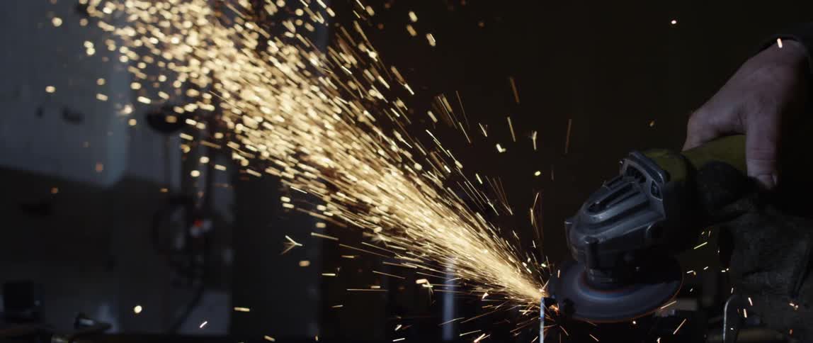 Sparks fly as a man works with a tool