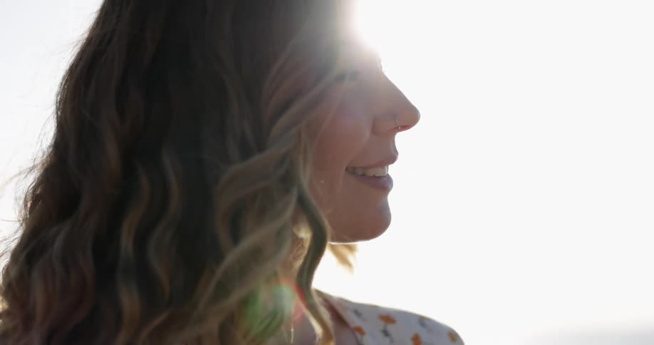 A woman is smiling on a sunny day