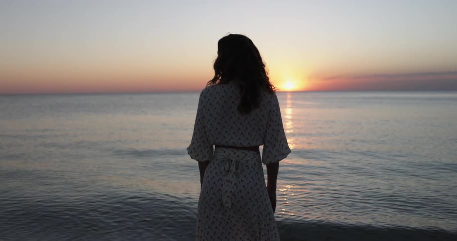 A woman standing at a sunset