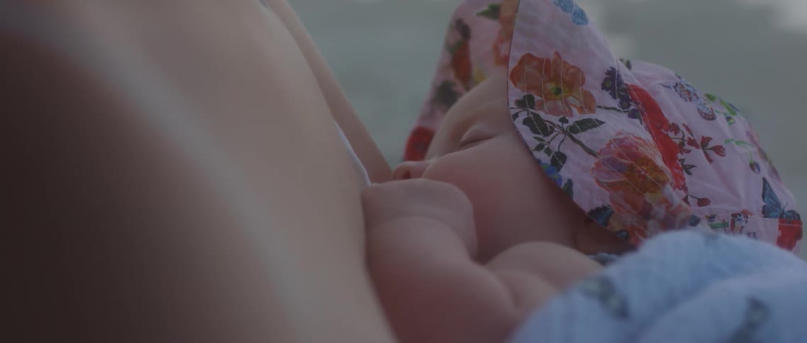 A baby sleeping against her mothers chest