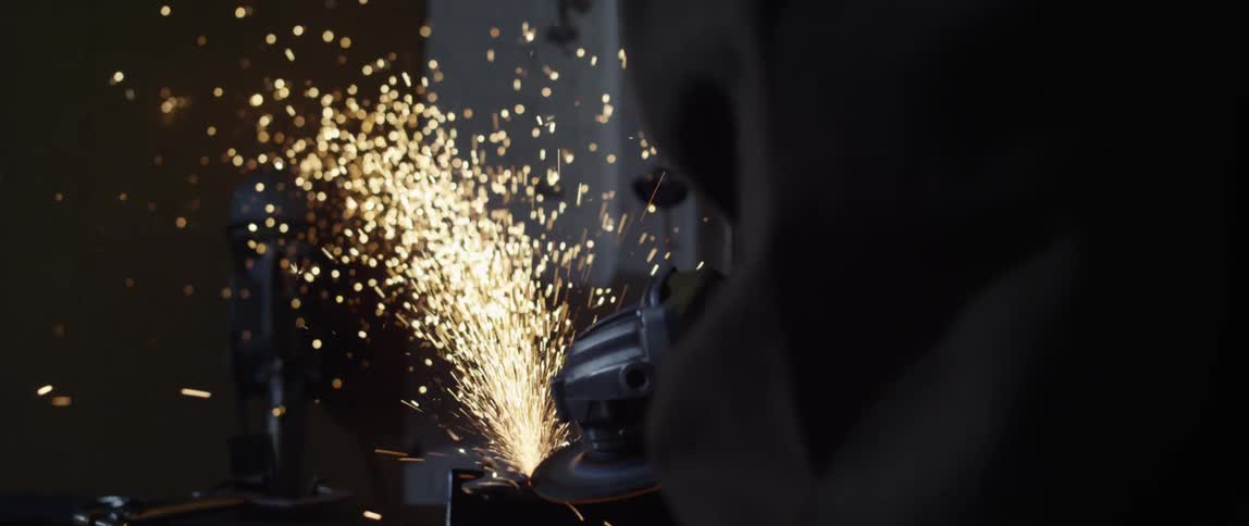 Sparks fly as a man uses a power tool