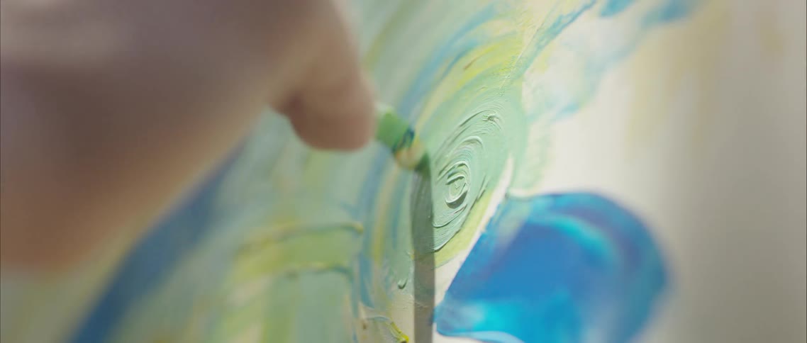 Paint brush painting green oil paint on white canvas