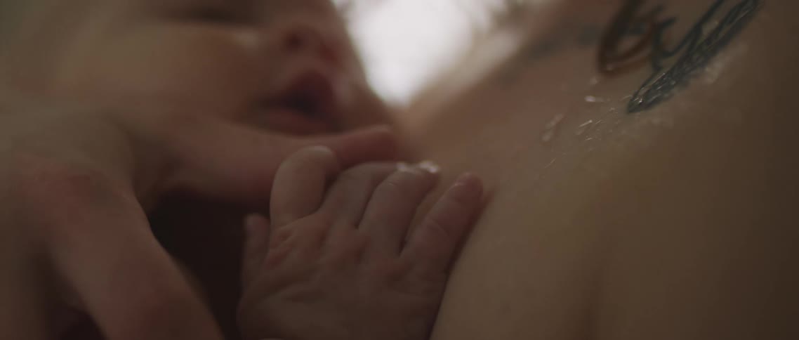A person holding a baby close to their chest