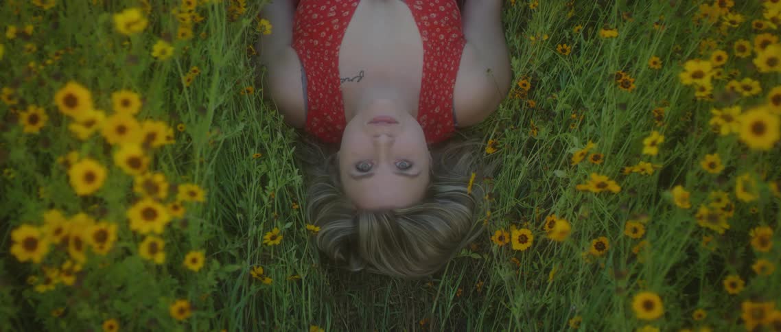 Birds eye view of a teenage girl lying in a field of flowers