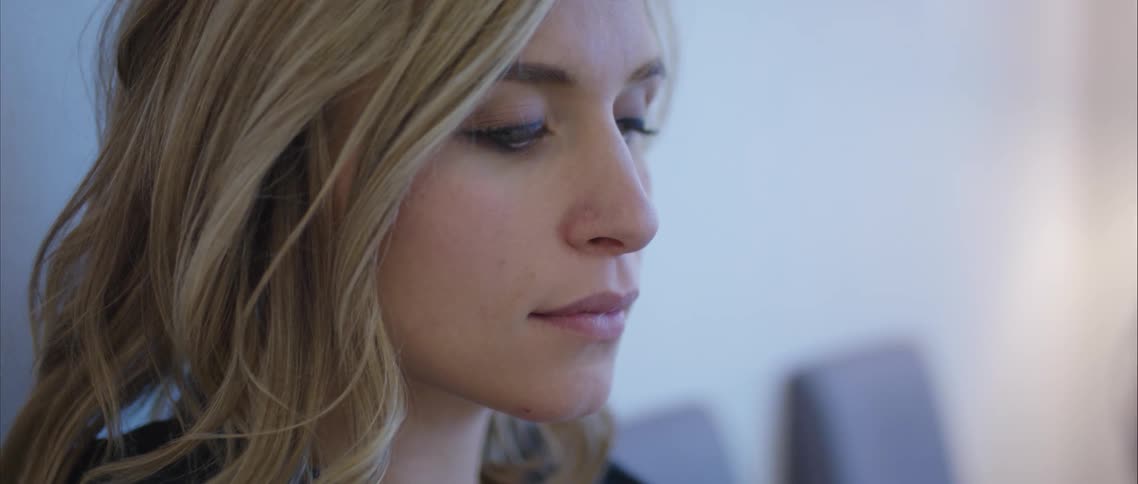 A woman sits in a room with another row of chairs