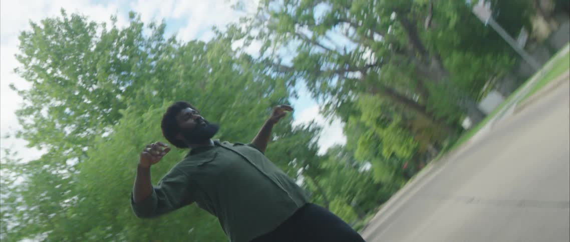 A man dancing in a neighborhood street