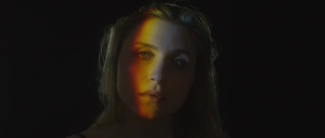 A woman slowly wakes in the dark