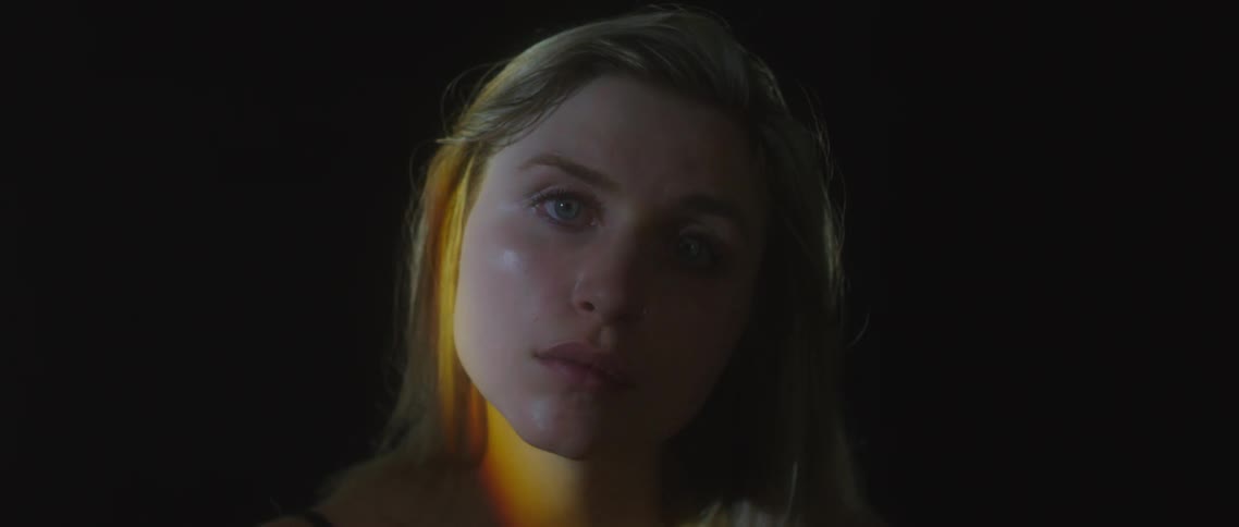 Woman with lights moving over face and black background