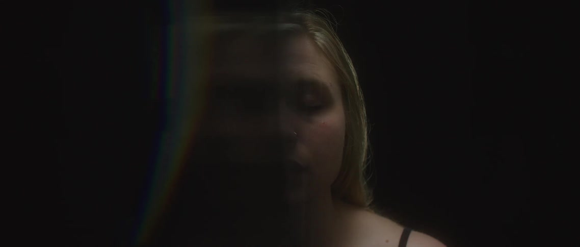 Woman standing behind a curtain with eyes closed