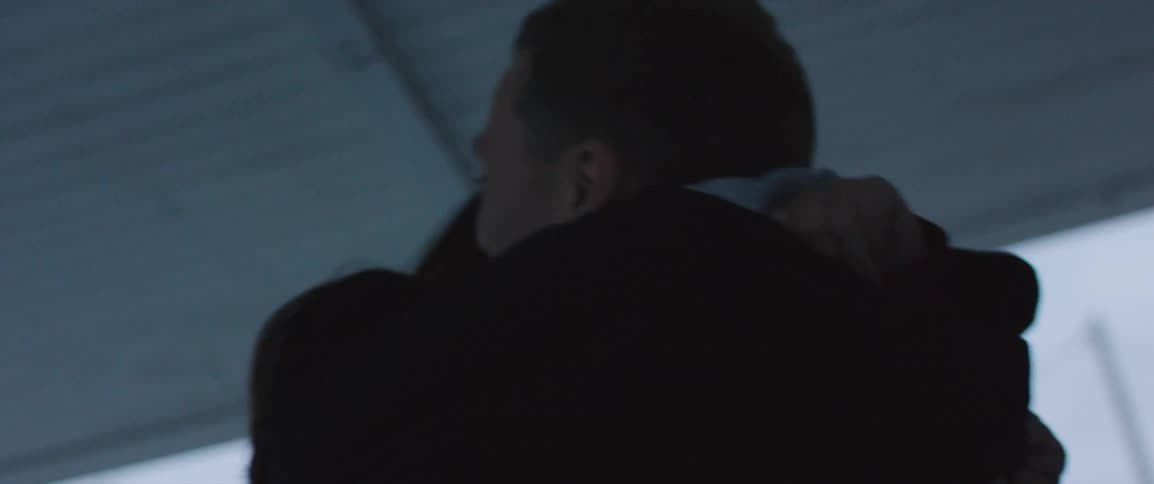 A man and woman hugging on a porch outside