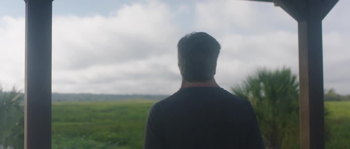 A man standing on a porch before walking away