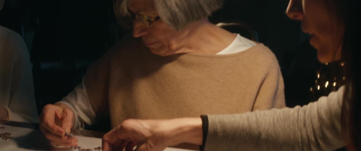 Two women sit at a table working on a puzzle
