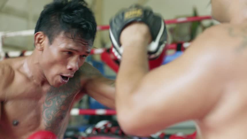 Two men punch each other in a boxing ring
