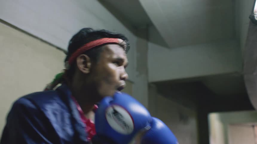 A man stands in a hallway practicing boxing