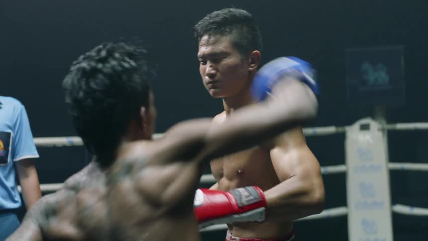 Two asian men in a boxing fight at a professional ring