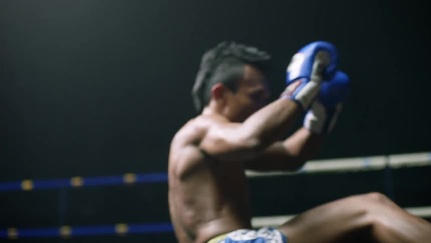 Two men fight in a boxing ring