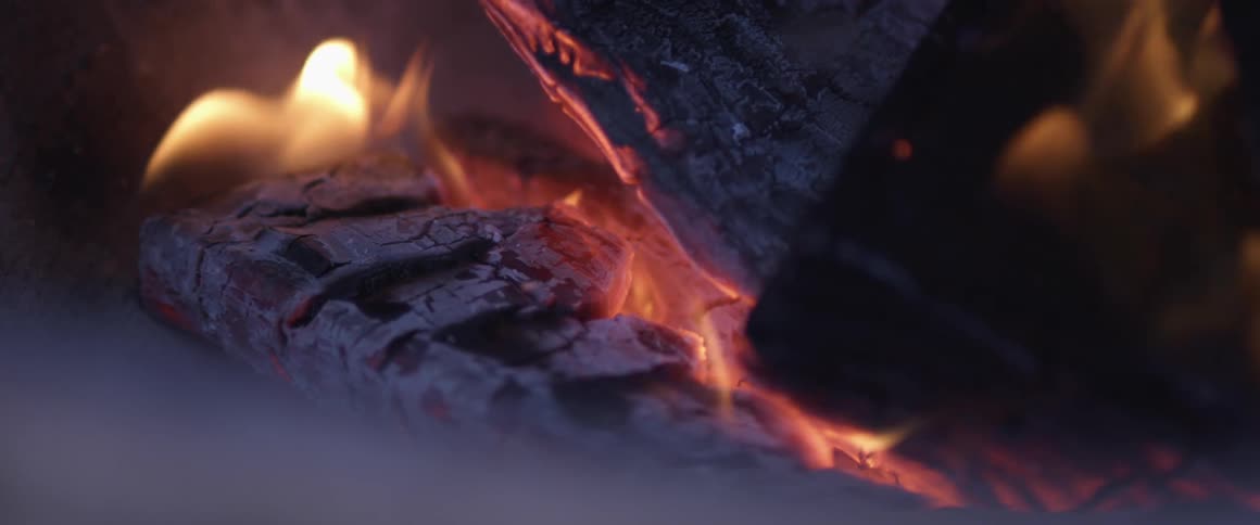 Flames burning on a log outdoors at night