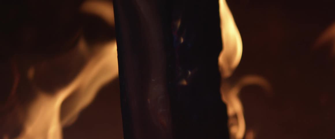 A piece of wood burning with fire and flames and smoke