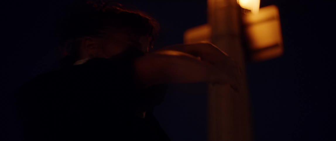 A woman is dancing outdoors at night