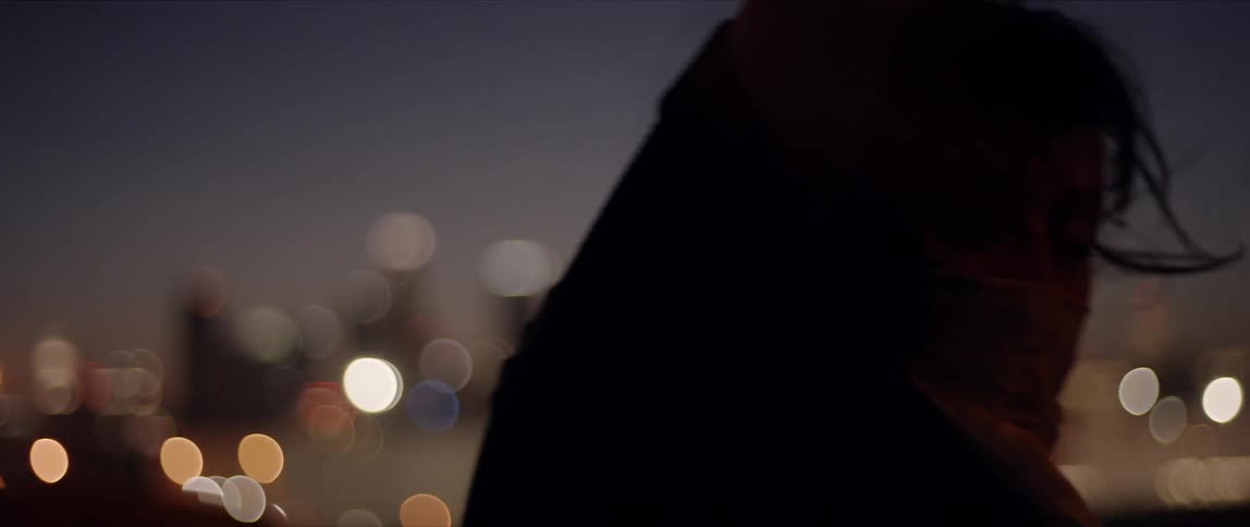 A woman is dancing outdoors by a city