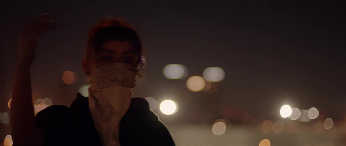 White woman dancing alone in the middle of the night at a urban area