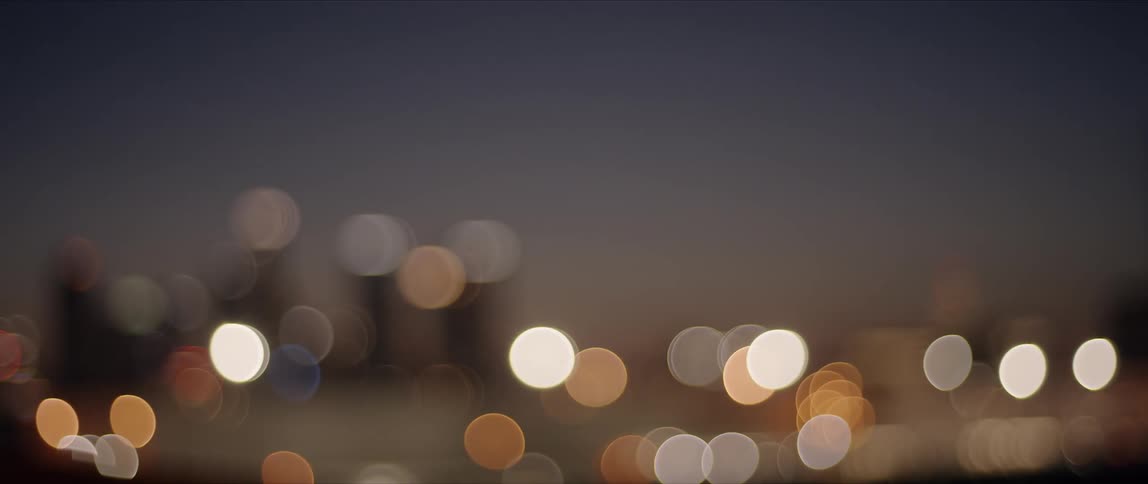 Lights from city skyline at night form blurry dots