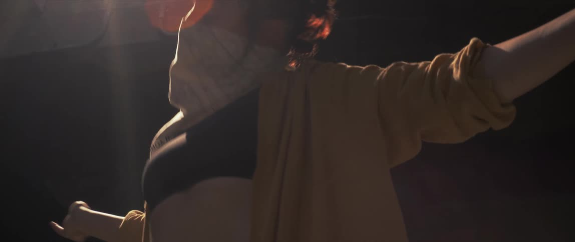 A woman wearing a face mask performs a dance routine