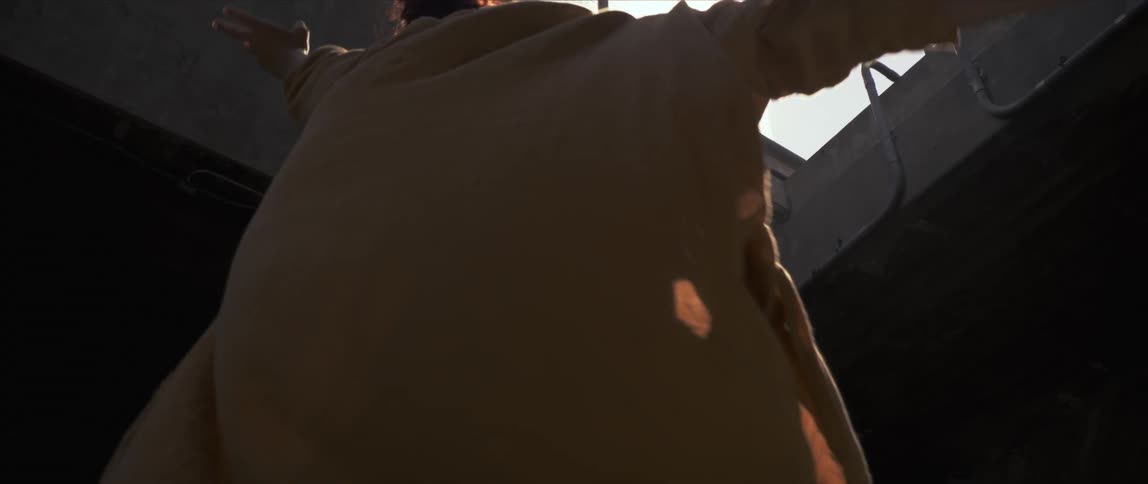 A woman is dancing outdoors at dusk