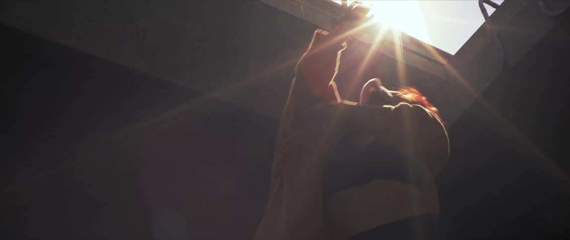 A woman dancing in a building with an open roof