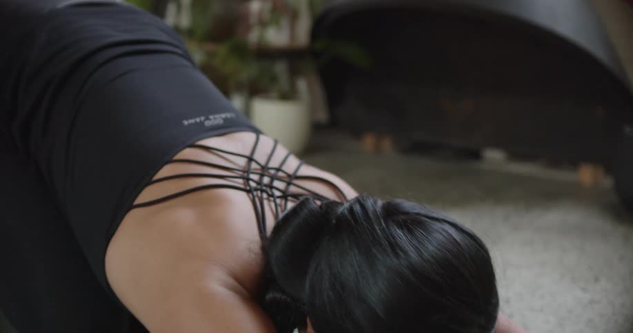 A woman is exercising indoors during the day