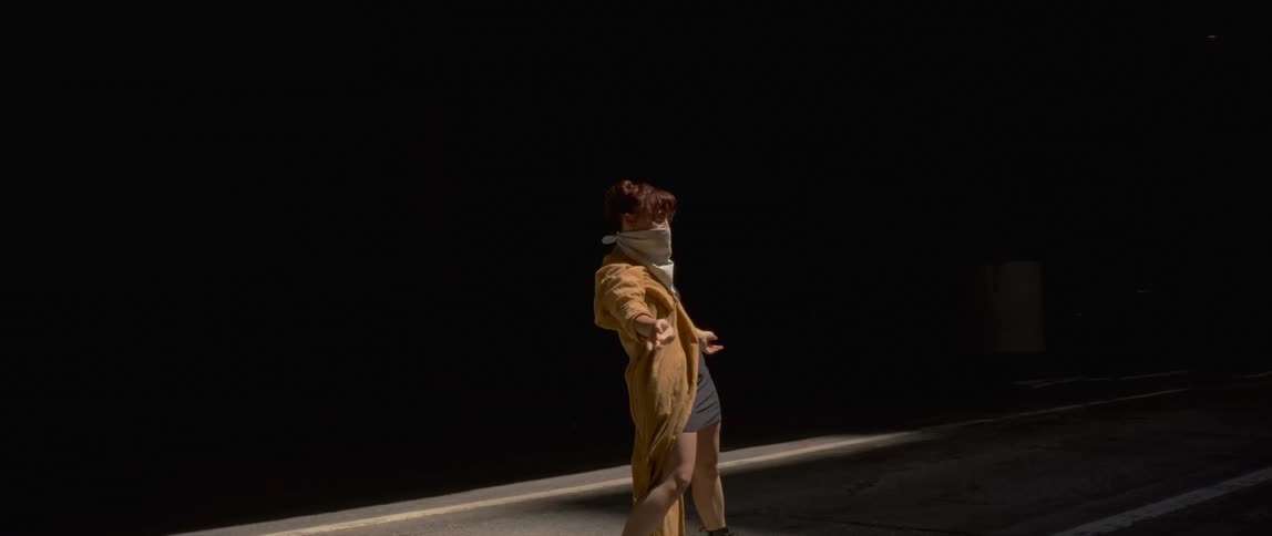 A woman is dancing in the middle of a city street