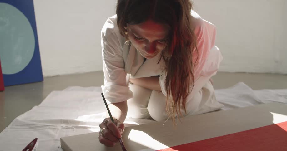 A woman painting on a large canvas