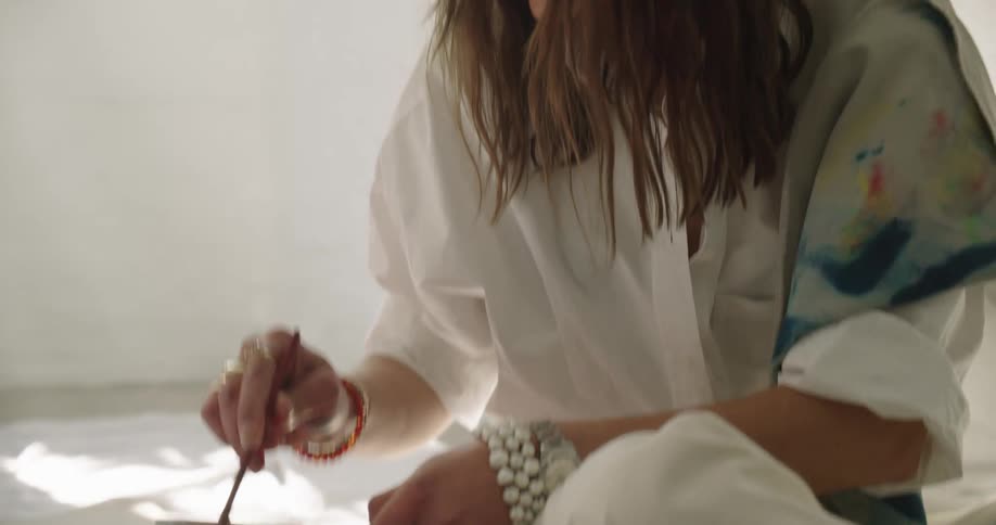 A woman mixing paint in a bowl