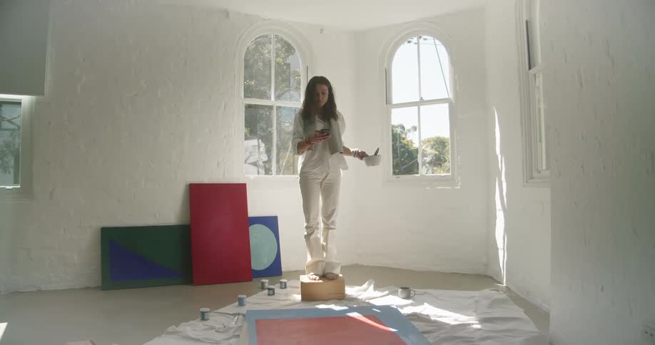 A woman taking a photo of a painting