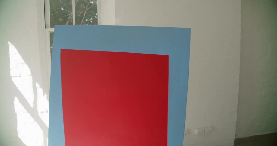A woman carries her painting in the room