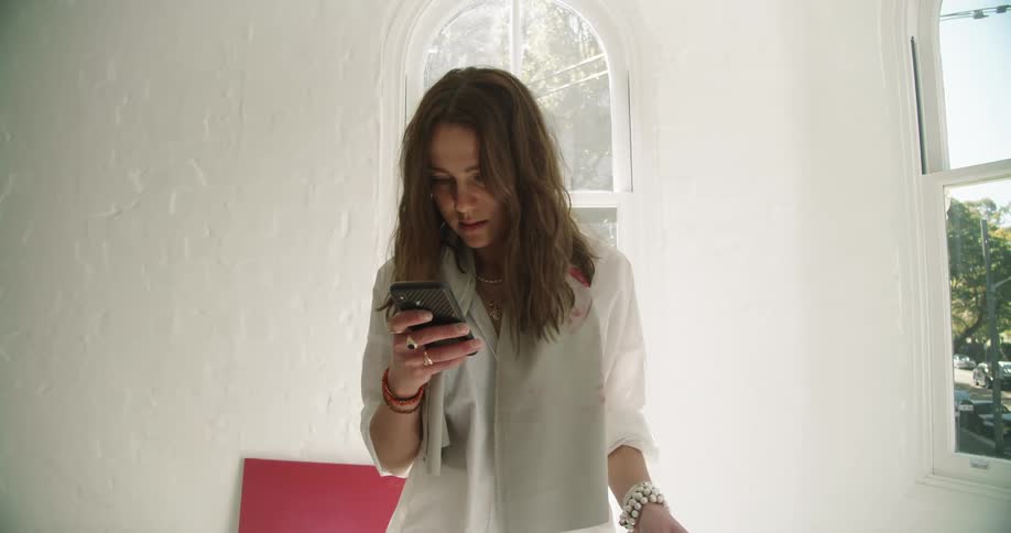 Woman checking her smartphone in a room at home