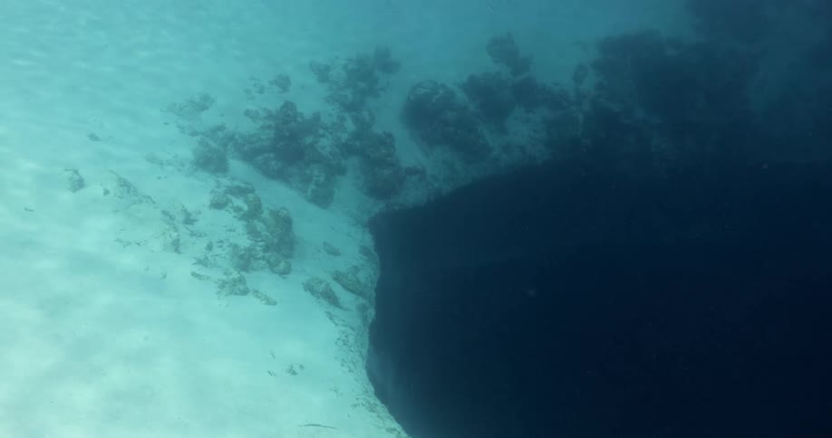 The surface of a blue hole underwater at daytime in the ocean