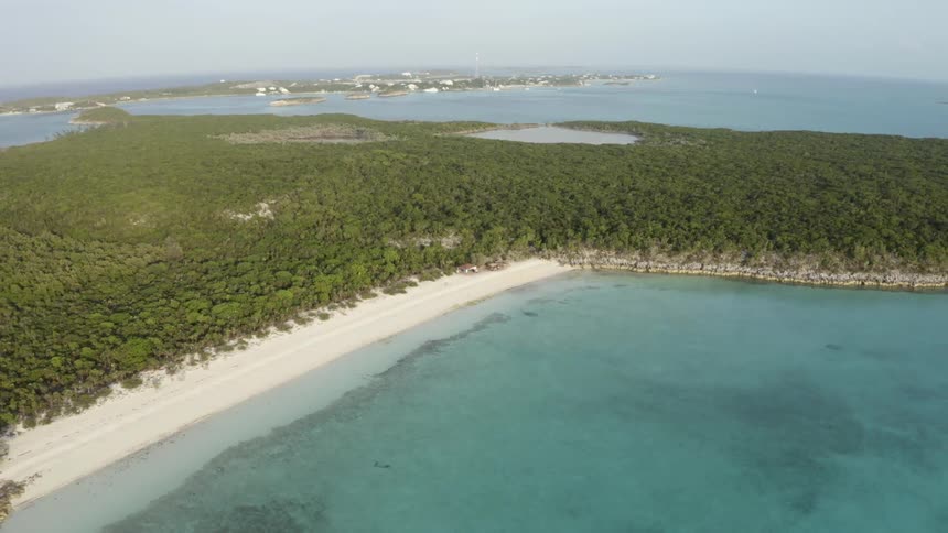 Aerial view of the green vegetation on a tropical island in the blue ocean waters