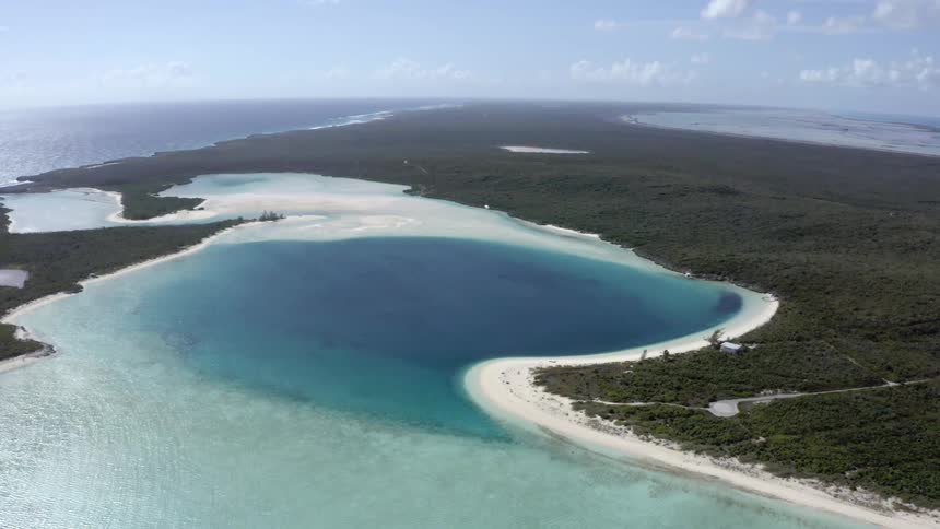 A deep bay surrounded by shallow water and land on a sunny day