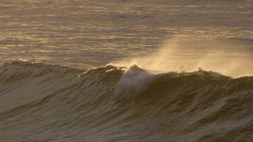 A man surfing on a large wave in the ocean
