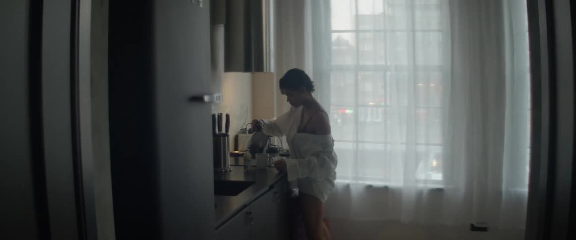 Woman pouring coffee into her cup at the kitchen