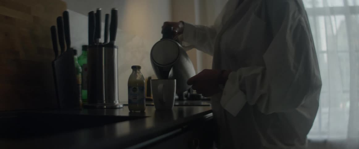A woman at home pours coffee in to a mug in the morning