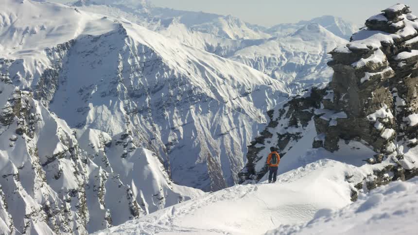 Mountains covered in snow with a person standing to one side